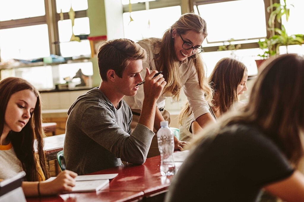 Mediensucht als Unterrichtsthema Lehrerin betreut Schülerinnen bei Projektarbeit