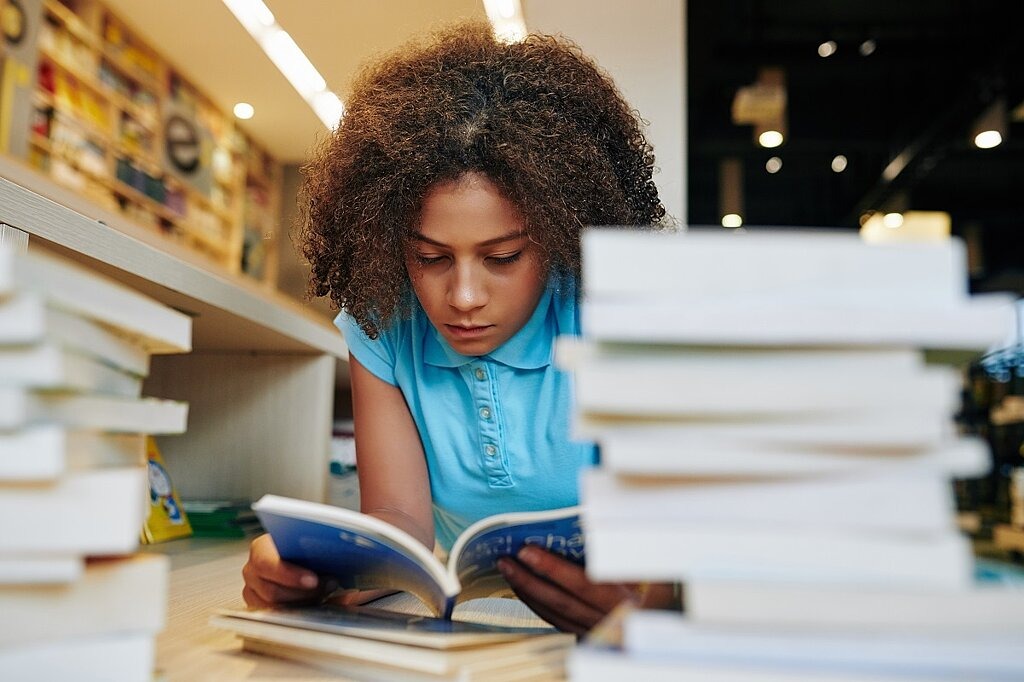 Lesen im Trend bei Jugendlichen Jugendliche liest in Bibliothek
