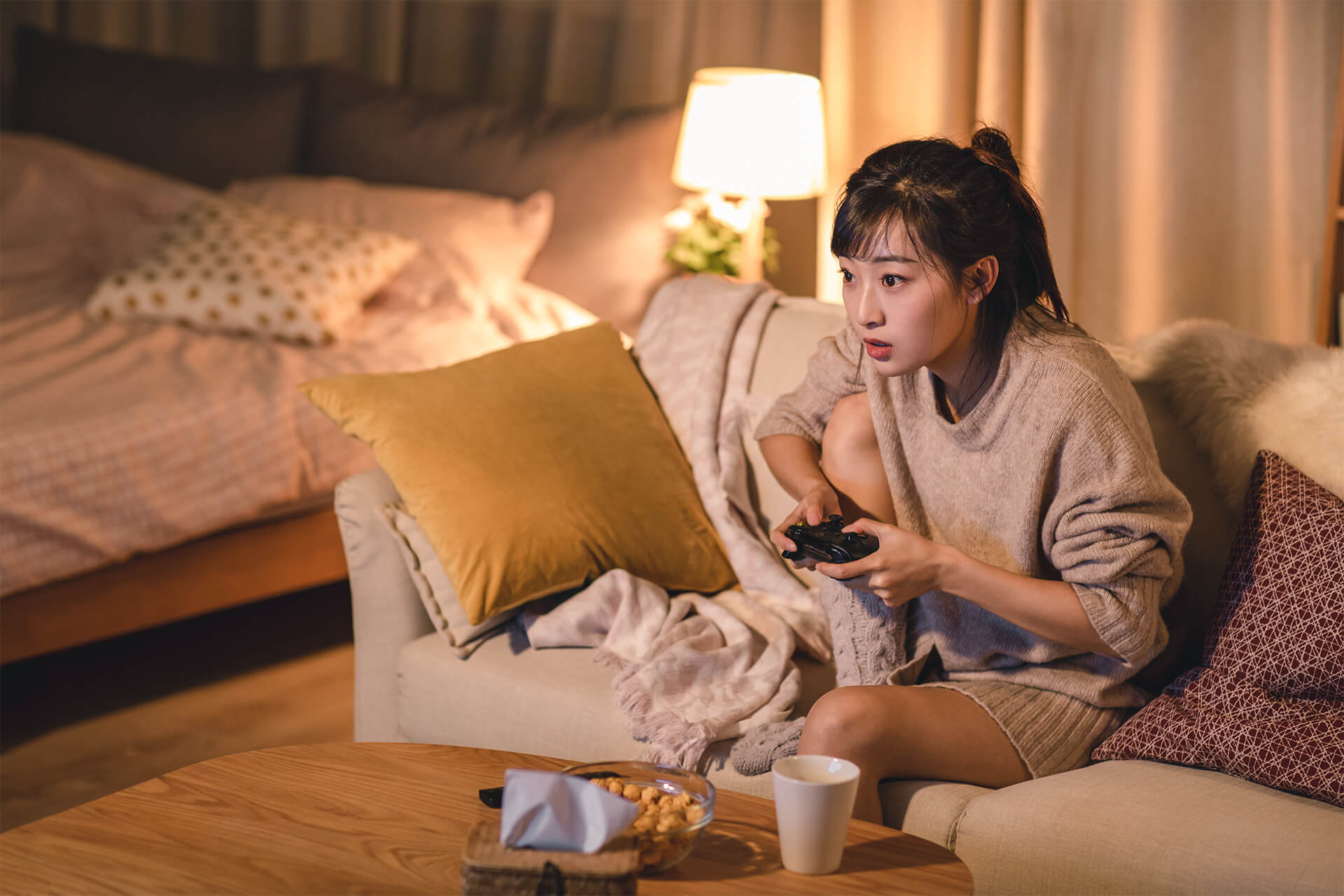 Asiatische Teenagerin spielt gebannt ein Videospiel.