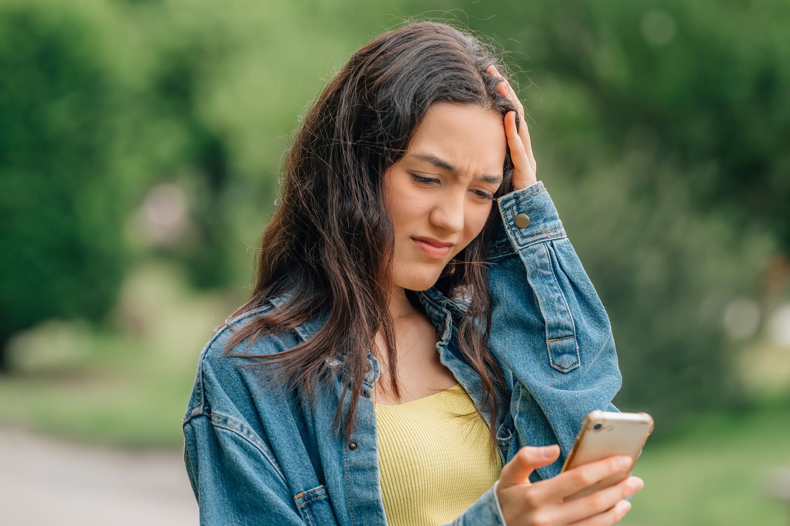 Jugendliche guckt besorgt auf ihr Smartphone