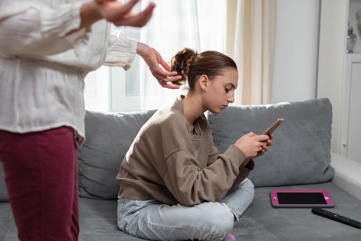 Mädchen mit Smartphone und Tablet auf dem Sofa