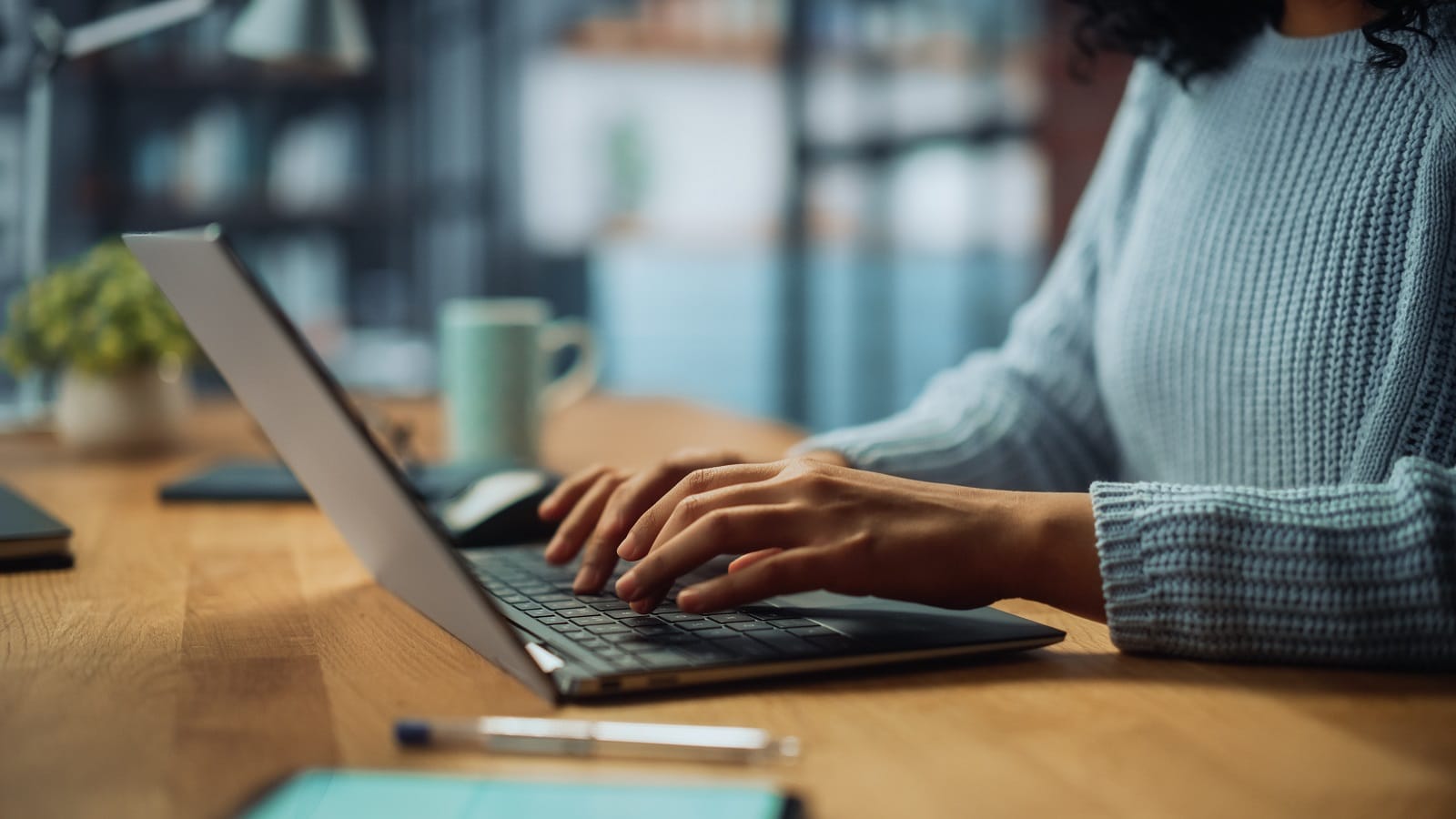 Nahaufnahme von Händen einer Frau, die auf einem Laptop tippen