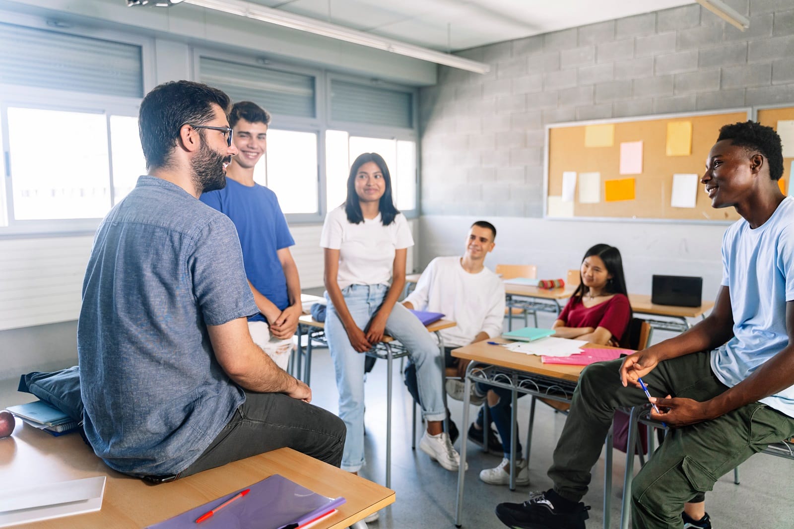 Junge Erwachsene sitzen gut gelaunt im Klassenzimmer