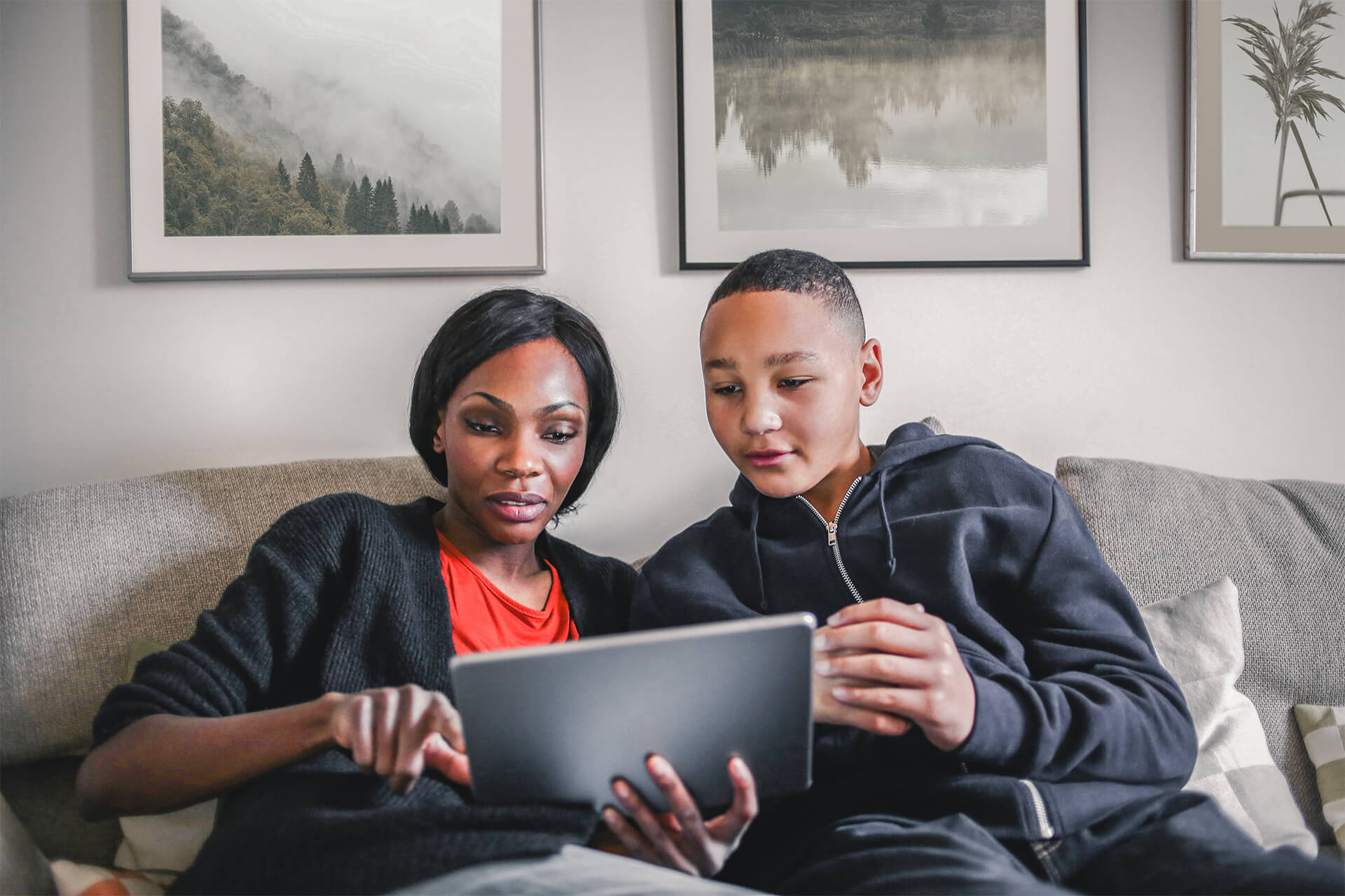 Mutter und Sohn auf Sofa mit Tablet