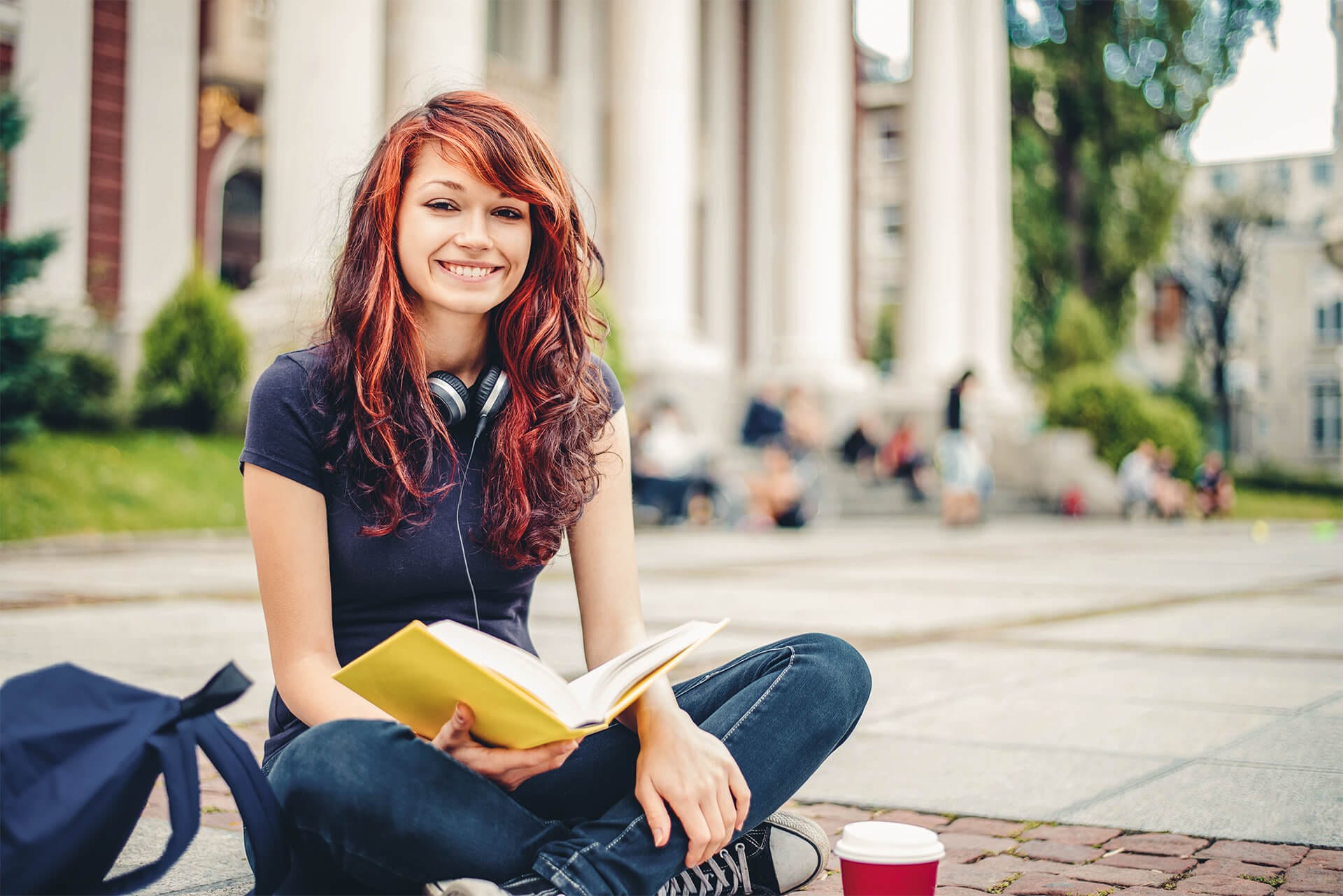 Mädchen sitzt auf Boden und mit Buch in der Hand