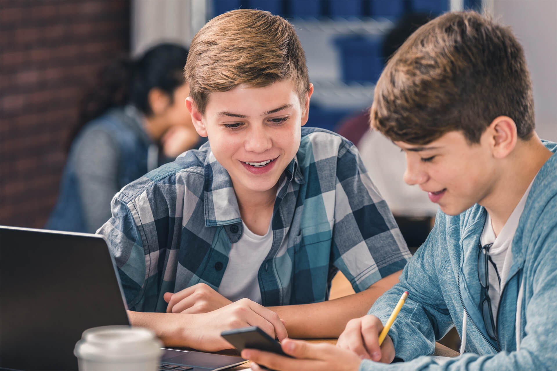 Zwei Schüler arbeiten zusammen am Laptop.