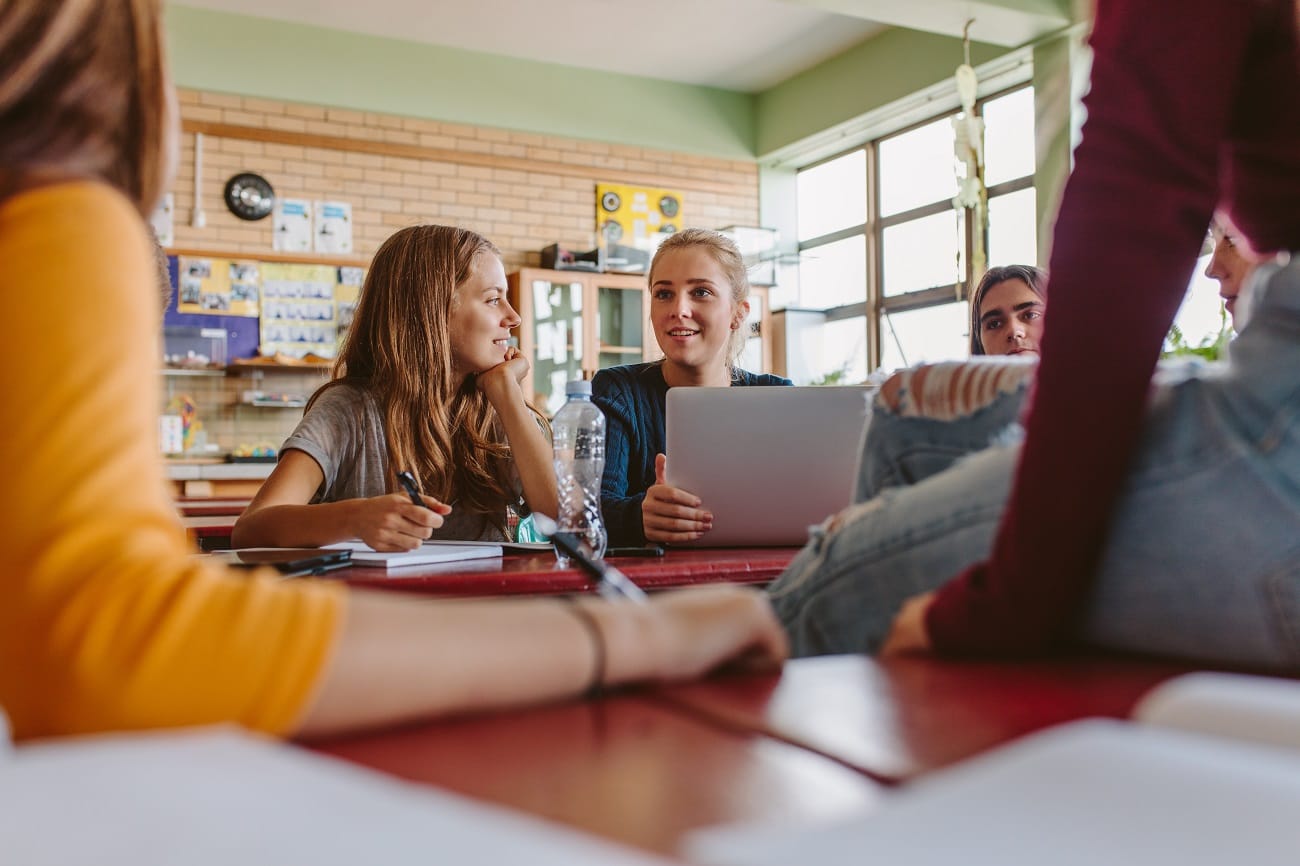 Jugendlichen im Klassenraum mit Laptop