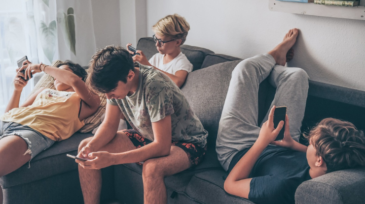 Jugendliche mit Smartphones auf Sofa